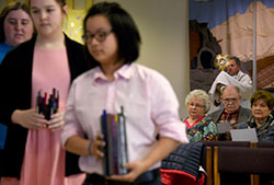 St. Teresa of Avila Catholic student center parishioners (left to right) Claire Brennecke, Grace Tam and Maggie Vail process with candles as Deacon Bob Marben carries a monstrance for Eucharistic Adoration and praying of the Divine Mercy Chaplet at the Valparaiso church on April 3. The teens are among five others at St. Teresa preparing to participate in World Youth Day this summer in Poland. (Anthony D. Alonzo photo)