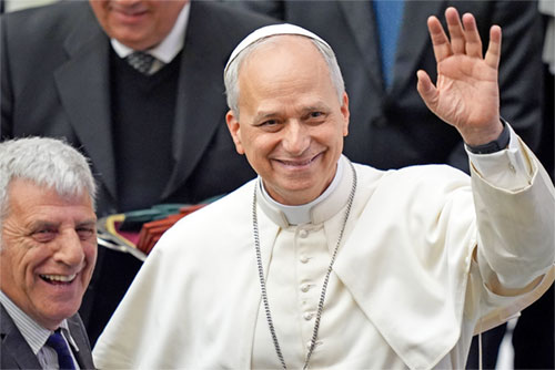 Pope Leo XIV greets photographers as he welcomes members of the media who covered his election, during a meeting in the Paul VI Audience Hall at the Vatican May 12, 2025. (CNS photo/Lola Gomez)