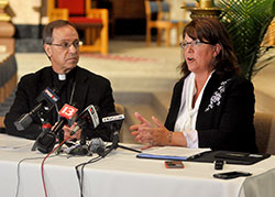 Archbishop Charles C. Thompson looks on as Gina Fleming, superintendent of Catholic schools for the Archdiocese of Indianapolis, speaks during a June 27 media gathering at SS. Peter and Paul Cathedral in Indianapolis. (Photo by Sean Gallagher)