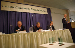 Jeffrey Stumpf, right, archdiocesan chief financial officer, speaks at the Catholic Community Foundation’s annual meeting in Indianapolis on Oct. 25. Seated are, from left, Toby McClamroch, a member of St. Luke Parish in Indianapolis and president of the CCF’s board of trustees, Archbishop Daniel M. Buechlein and Joseph Therber, executive director of the archdiocesan Secretariat for Stewardship and Development.