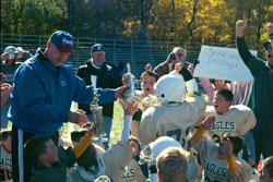 Roncalli High School head football coach Bruce Scifres presents both the championship trophy and the runner-up trophy to the players of Our Lady of the Greenwood Parish’s third- and fourth-grade “Green” and “Gold” teams. The two teams met in the championship game of the 3/4 AA CYO tournament, a game that ended 0-0. (Photo courtesy David Matthews) 