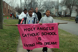Holy Angels sixth-graders Charles Davis, left, and Desmond Huskie carry a banner on Jan. 12 during the school’s annual march honoring the life and ministry of Dr. Martin Luther King Jr. Students from St. Anthony School also participated in the march and memorial Mass.