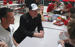 Father Peter Gallagher, the Colts’ chaplain, talks with students at Cardinal Ritter Jr./Sr. High School in Indianapolis on Jan. 22 -- the day after the Indianapolis Colts won the AFC Championship game. He is sporting the official championship hat given to him at the end of the game. (Photo by Sean Gallagher) 
