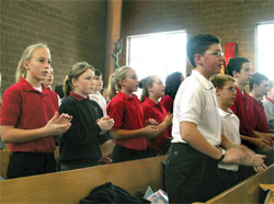 Seventh-grade students from St. Jude School in Indianapolis clap their hands during a hymn at the Jan. 24 Mass at St. Jude Church honoring St. Theodora Guérin. (Photo by Mike Krokos) 