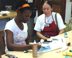 Ciera Harris, who will be a seventh-grader at St. Lawrence School in Indianapolis, works on a puppet of a character she read about during an Art with a Heart camp held on July 11 at St. Philip Neri School in Indianapolis. Carol Conrad, a member of St. Simon the Apostle Parish in Indianapolis and founder of Art with a Heart, looks on.	