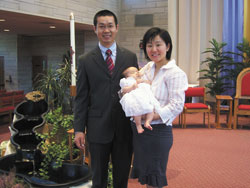 Weimao and Carrie pose with their daughter Lucy after the infant was baptized on May 6 at the St. Paul Catholic Center in Bloomington. (Submitted photo) 