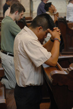 Seminarian Martin Rodriguez, a junior at Marian College in Indianapolis and a resident of the Bishop Simon Bruté College Seminary, prays on Aug. 15 at the Church of the Immaculate Conception on the grounds of the motherhouse of the Sisters of Providence of Saint Mary-of-the-Woods. Rodriguez helped organize an effort over the summer where eight seminarians and members of the Nigerian-based Daughters of Mary Mother of Mercy went door to door in the neighborhoods surrounding the Mother Theodore Catholic Academies to encourage families there to enroll their children in the schools.