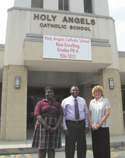 Smiles mark the celebration at Holy Angels School for its 100th anniversary. Student Mya Terrell, left, poses with the school’s campus director, Michael Joseph, and principal, Cindy Greer.