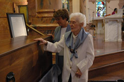 Providence Sister Marie Ellen Sullivan, a retired sister who lives at the motherhouse, and St. Patrick parishioner Teresa Clark of Terre Haute venerate the remains of St. Theodora Guérin after the saint’s first feast day Mass on Oct. 3 at the Church of the Immaculate Conception at Saint Mary-of-the-Woods. Clark is the artist who created the official sculpture of the eighth American saint. It has been reproduced in several sizes.