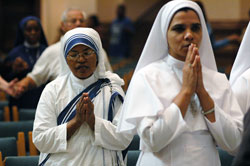 Missionaries of Charity Sister M. Sumati, left, and Franciscan Sisters of the Immaculate Heart of Mary Sister Sabeena Mary pray during the World Mission Sunday Mass on Oct. 21 at SS. Peter and Paul Cathedral in Indianapolis.