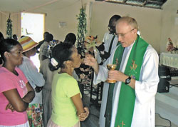 Father Steve Schwab distributes Communion during one of the Masses he celebrated at St. Jean-Marie Vianney Parish in Haiti in September. (Submitted	photo)	