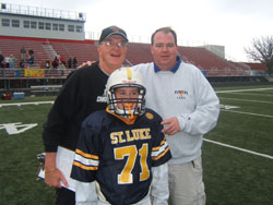 Joe Bill, CYO football coach at Christ the King Parish in Indianapolis, is shown with his son, Jude Bill, CYO football coach at St. Luke the Evangelist Parish in Indianapolis. The football player pictured is Jude Bill, the grandson and son of the two coaches. (Submitted photo) 