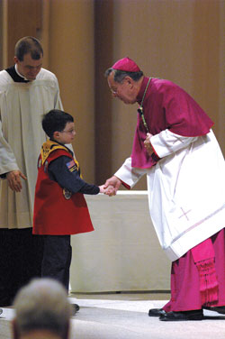 Archbishop Daniel M. Buechlein congratulates a Cub Scout during the Religious Emblems Presentation for Scouts on Feb. 11 at SS. Peter and Paul Cathedral in Indianapolis. (File photo/Brandon A. Evans) 