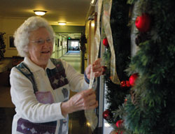 St. Paul Hermitage resident Joan Shevlin straightens a ribbon on a Christmas wreath on Nov. 29 near the chapel at the retirement home operated by the Sisters of St. Benedict of Our Lady of Grace Monastery in Beech Grove.	