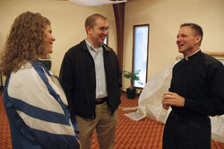 Father Rick Nagel, right, chats with, from left, Jill Riley and Brian Buchanan on Jan. 13 at Our Lady of the Greenwood Parish in Greenwood, where Father Nagel serves as associate pastor. Riley and Buchanan work for the Future Farmers of America, an organization that Father Nagel worked for before discerning a call to the priesthood. (Photo by Sean Gallagher) 