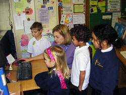 St. Anthony of Padua School first-grade teacher Jacquelyn Singleton looks at photos of Italy on her computer with students. Singleton and her husband, Tony, toured Italy from Nov. 26 to Dec. 6. (Photo by Patricia Happel Cornwell)