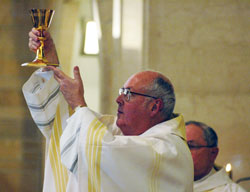 Msgr. Joseph F. Schaedel, vicar general, elevates the Blood of Christ as he celebrates Mass on May 20, 2007, at Holy Name of Jesus Church in Beech Grove on the occasion of his 25th anniversary of ordination to the priesthood. He is the keynote speaker for the fourth annual Catholic Pro-Life Dinner on March 8 in Indianapolis. (File photo by Mary Ann Wyand)	