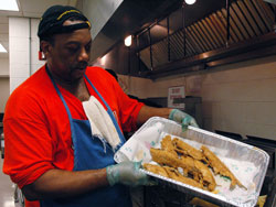 Holy Angels parishioner Reggie Ash of Indianapolis displays a tray of “whole cats,” breaded catfish that he deep-fried during the Indianapolis West Deanery parish’s Lenten fish fry on Feb. 8 at the Holy Angels School cafeteria. (Photo by Mary Ann Wyand)	