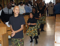 Holy Angels parishioner Ikeena Stovall of Indianapolis leads the Global Children, African Dancers as they process into St. Rita Church on March 2 for a traditional African liturgy. His mother, Sally Stovall, founded the dance group in June 2006. (Photo by Mary Ann Wyand) 