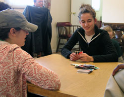 Alyssa Grengs, left, and Anna Peterson play a card game with children at Miracle Place, an Indianapolis center operated by Providence sisters that helps at-risk students, senior citizens and Hispanic people. Grengs and Peterson are Creighton University students who spent their spring break in ­Indianapolis working to make a difference in the lives of others. (Photos by John Shaughnessy) 