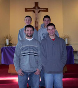 The Allstott brothers stand in front of the crucifix at Our Lady of the Springs Church in French Lick, the parish where they grew up. Pictured in this 2003 photo are, from left, front row, Michael and Jacob, and, back row, Ezekiel and Luke. (Submitted photo) 