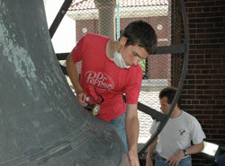 Our Lady of the Most Holy Rosary parishioners Ryne Friederick, left, and his father, Jerry, of Indianapolis begin restoration work on the bronze surface of the 7,000-pound San Salvador bell in the west belfry at the historic Italian church in Indianapolis on May 31. Ryne completed his Eagle Scout project in time for Holy Rosary Parish’s 25th annual Italian Street Festival on June 13-14. (Photo by Mary Ann Wyand)