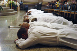 Deacon candidates lay prostrate during their ordination Mass on June 28 at SS. Peter and Paul Cathedral in Indianapolis. (Photo by Sean Gallagher)	