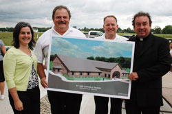 Project architect Diane Guljas of Sebree Architects Inc. stands with, from left, Nova Gilliatte, superintendent of Eden Enterprises; Stan Schutz, president of Eden Enterprises; and Father Glenn O’Connor, pastor of St. Ann and St. Joseph parishes in Indianapolis, with an architectural rendering of the new St. Ann Church after the June 29 groundbreaking ceremony. Eden Enterprises will build the new church and social hall, which will be completed in early 2009. (Photo by Mary Ann Wyand) 