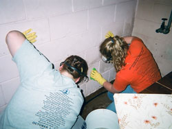 Two Homeland Mission participants work cleaning a wall affected by the recent flooding in central Indiana. (Submitted photo) 