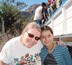 Alice Mattingly, left, and Blanqui, a resident of Portillo, El Salvador, smile for the camera during one of Mattingly’s mission trips to Portillo. A third-grade teacher at St. Pius X School in Indianapolis, Mattingly has made about 15 trips to the remote village in the El Salvadoran mountains and helped get her North Deanery parish and school involved in outreach efforts to the Central American country. (Submitted photo) 