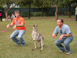 Two archdiocesan World Youth Day pilgrims do the “kangaroo hop” with a resident of the Australia Zoo near Beerhwah on July 12. (Photo by Katie Berger) 