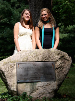Cousins Ashley Vermillion, left, and Jena Thralls stand by a historical marker on the campus of Saint Mary-of-the-Woods College. The rock memorializes the moment in 1840 when St. Theodora Guérin ended a three-month journey from France and arrived in the Indiana wilderness where she was welcomed and given shelter by the ancestors of Ashley and Jena, who are both freshmen at the college. (Submitted photo by Lynn Hughes) 