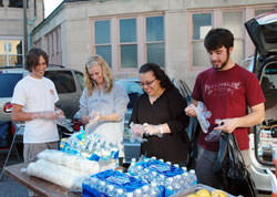 Catholic young adults set up food and water to serve a meal to homeless people in Indianapolis in September. College students and other young adults are the focus of a revived effort by the archdiocese to connect with young people during a critical period in their faith development. (Submitted photo) 