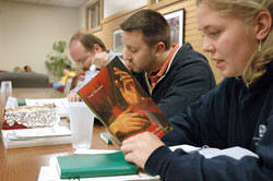 Julie Lasher, a student at Marian College in Indianapolis, reads from a book by the late Father Luigi Guissani, the founder of the international Catholic lay movement Communion Liberation, during a Nov. 9 “School of Community” meeting at the Ruth Lilly Student Center on Marian’s campus. Listening to Lasher are, from left, Filippo Pattacinni and Rick Rush. (Photo by Sean Gallagher) 
