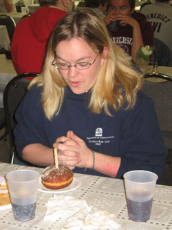 Kelsey Wilson of St. Thomas More Parish in Mooresville prays before eating her dessert during the trip to New York to see Pope Benedict XVI in April. (Submitted photo) 