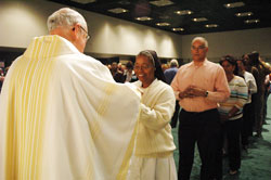 Dominican Sister Diana Dorlorita, a catechetical minister in Curacao in the Netherlands Antilles, receives Communion on March 25 from Msgr. Joseph F. Schaedel, vicar general, during the opening Mass of the National Catholic Educational Association’s annual convention at the Indiana Convention Center in Indianapolis. (File photo by Sean Gallagher) 
