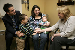 Dr. Melanie Margiotta, right, holds the hand of Benjamin Lam, second from left, while his parents, Carlos and Judy Lam, and his little brother, Oliver, visit Margiotta on Feb. 11 at her office in Indianapolis. Margiotta is the “NFP-only” family physician for the Lam family. Another NFP-only physician, who received training at the Pope Paul VI Institute in Omaha, Neb., successfully corrected Judy’s endometriosis, which had caused infertility. (Photo by Sean Gallagher) 