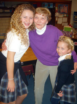 A teacher for 44 years at St. Louis School in Batesville, Lil Kennel shares a hug with students Lizzy Moeller, left, and Anna Moeller. (Submitted photo) 