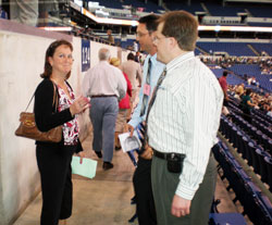 Julie Carr, a member of St. Malachy Parish in Brownsburg, gets assistance from volunteers Christopher Breen and Michael Hussey before the start of the 175th anniversary Mass at Lucas Oil Stadium in Indianapolis on May 3. Breen and Hussey are also members of St. Malachy Parish in Brownsburg. (Photo by Mike Krokos) 