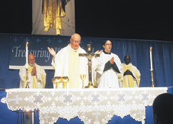 Msgr. Joseph F. Schaedel celebrates Mass during the “Treasuring Womanhood” conference on April 18 at the Indianapolis Convention Center. Also pictured, from left, are Msgr. Harold Knueven, administrator of St. Mary Parish in Greensburg; altar server Timothy DeCrane, a member of Our Lady of the Most Holy Rosary Parish in Indianapolis; and Father Luca Amandua, a priest visiting from the Diocese of Arua, Uganda. (Photo by Ann Margaret Lewis) 