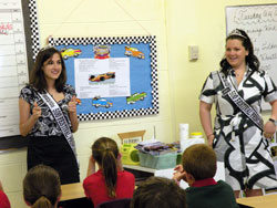 Elizabeth Wheatley, left, and Lindsey Fitzgerald, both 2009 500 Festival princesses, quiz fourth-grade students at St. Matthew School in Indianapolis about race day trivia. The princesses, who both attended Catholic schools, visit schools, hospitals and nursing homes to promote the Indianapolis 500. (Photo by Kamilla Benko) 