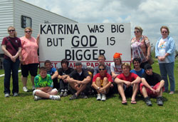 Students and adults from Holy Cross Central School in Indianapolis pose in front of a sign that reflects the source of their week-long effort to help people whose lives were devastated by Hurricane Katrina. (Submitted photos) 