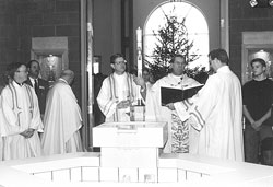 Archbishop Daniel M. Buechlein prays during the dedication Mass for the new St. Jude Church on Dec. 21, 1997. The old church building was converted into a cafeteria for the school. (Archive photo)