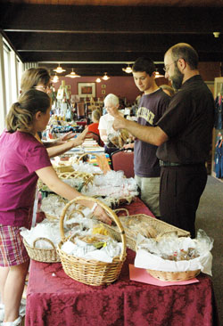 Father Todd Goodson, pastor of St. Monica Parish in Indianapolis, buys baked goods on Aug. 1 during the fourth annual “Missions Helping Missions Bazaar” at Our Lady of Fatima Retreat House in Indianapolis. (Photo by Mary Ann Wyand)