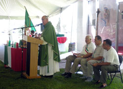 Msgr. Joseph F. Schaedel, vicar general and pastor of Our Lady of the Most Holy Rosary Parish in Indianapolis, delivers the homily during the Aug. 16 Mass at Camp Atterbury. The Gospel reading was proclaimed in both English and Italian. (Photo by Mike Krokos)