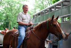 Marian University President Daniel Elsener gets ready to take a horse ride on the Indianapolis campus this summer—part of his preparation to fulfill a promise he made to the university’s football players. Elsener told the team he would ride a horse and lead them onto the field when the university’s new sports stadium officially opens on Sept. 19. (Submitted photo) 