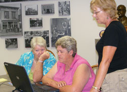 Catholic Charities Tell City and the Tell City-Perry County Public Library have teamed up to offer computer assistance to people in need during the economic crisis. Client-turned volunteer Rita Dale, left, client Patsy Faucett and volunteer Linda Hubert work together to file an unemployment claim on a library computer. (Submitted photo) 