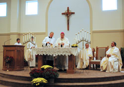 Archbishop Daniel M. Buechlein, assisted by Father Patrick Beidelman, the master of ceremonies, prays the first eucharistic prayer during the Mass of Blessing a Church and Altar on Sept. 26 at the new St. Ann Church in Indianapolis. Father Harold Rightor II, seated at right near the altar, served as associate pastor of St. Ann Parish from 2007-09 and now serves as pastor of Annunciation Parish in Brazil. Father Glenn O’Connor, pastor of St. Ann and St. Joseph parishes in Indianapolis, is seated at the far right side of the altar. (Photo by Mary Ann Wyand) 