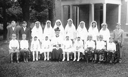 Members of the first and solemn Communion classes of 1932 at Immaculate Conception Parish in Millhousen pose with their pastor, Father Carl Riebenthaler. Ruth Beesley, sixth from left in the back row, 92, recently recalled how the priest, who served as the parish’s pastor for 43 years, was greatly loved by the members of the parish. (Submitted photo)