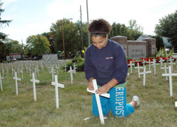 St. Michael School eighth-grader Briana Stewart of Indianapolis helped hammer crosses into the ground on Sept. 19 with her parents, Grant and Naomi Stewart, and her older twin sisters, Madeline and Melinda. They are members of St. Michael the Archangel Parish. More than 100 parishioners and students from St. Michael School, Cardinal Ritter Jr./Sr. High School, Bishop Chatard High School and Marian University, all in Indianapolis, helped erect the pro-life display. (Photo by Mary Ann Wyand) 